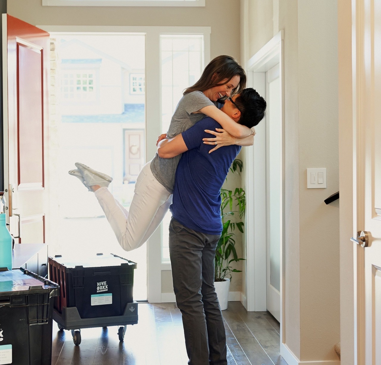 A couple hugging each otherwith a moving box in the background