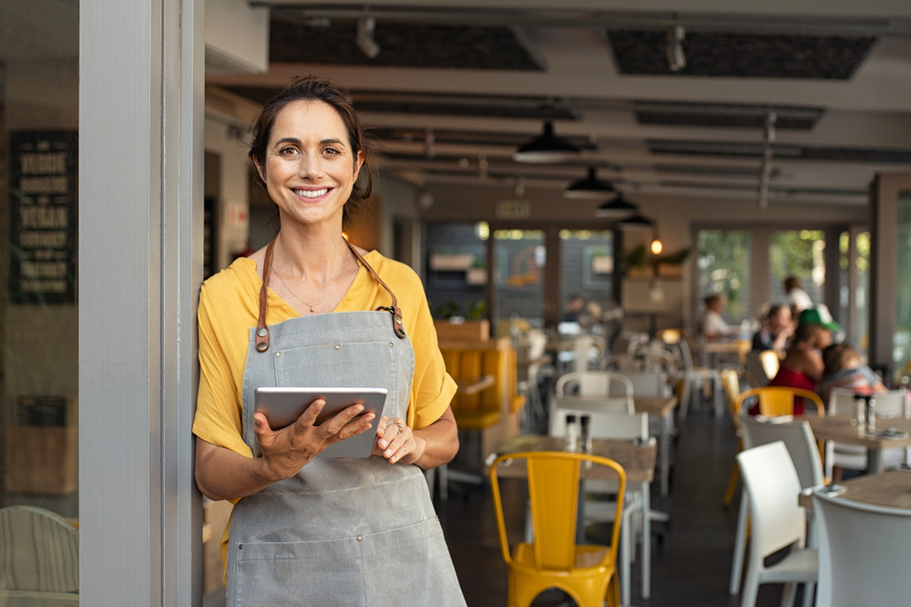 cafe waiter at the door with a tablet