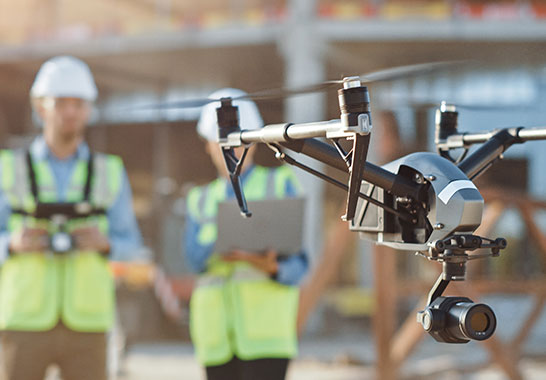 worker flying a drone with a camera on it