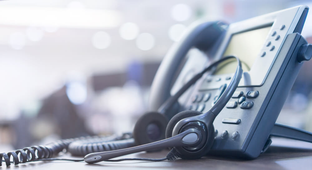 Business phone and headset on a desk in an nbn™ connected office.