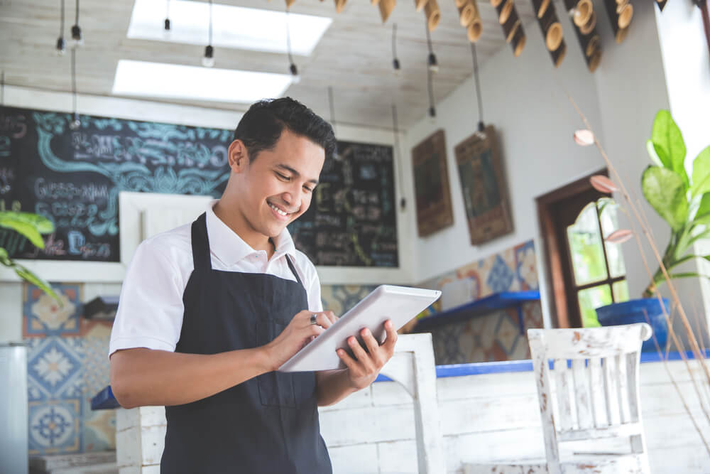 Small business owner using a tablet, supported by business nbn™ internet.