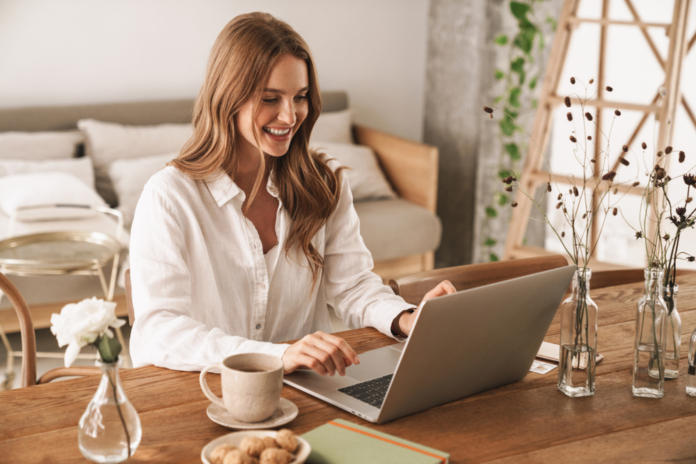 smiling lady sitting at her desk on her laptop